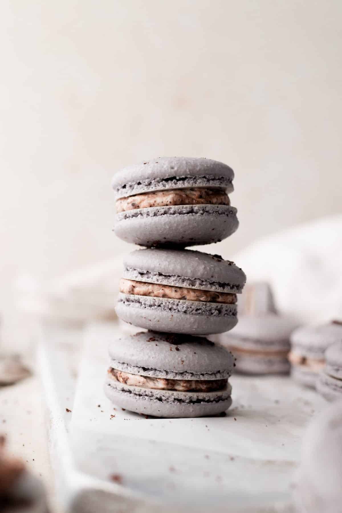 three cookies and cream oreo macarons stacked.