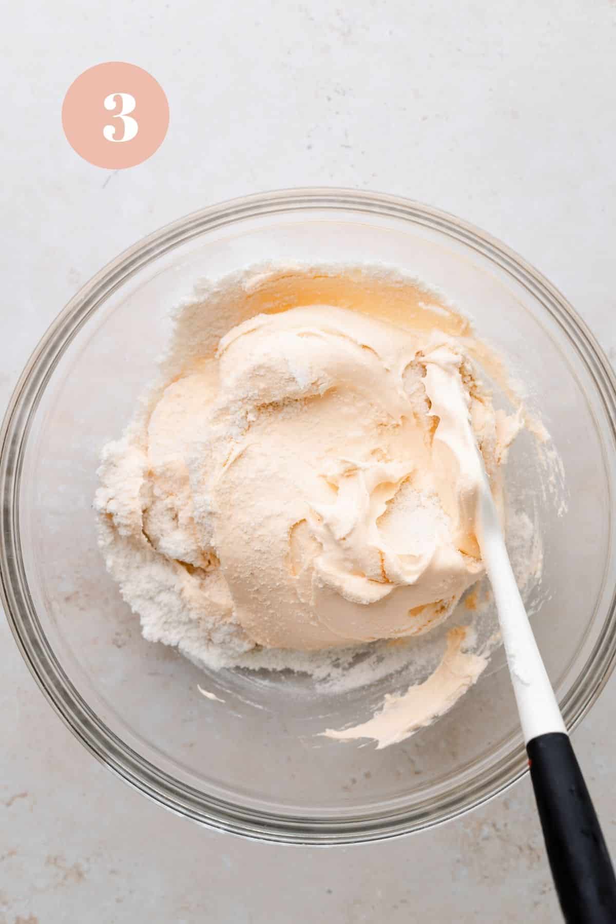 orange macaron batter being mixed.