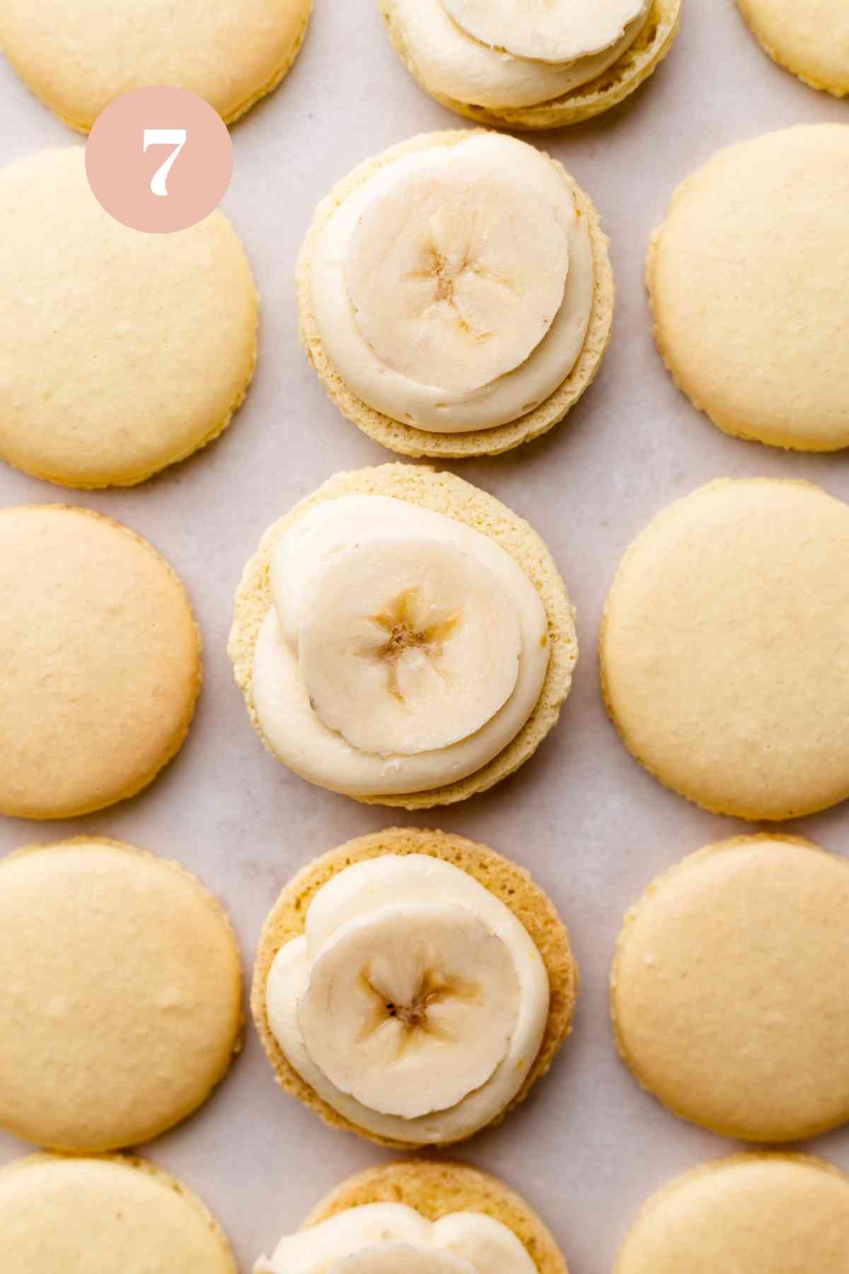 the filled banana macarons on a sheet tray.