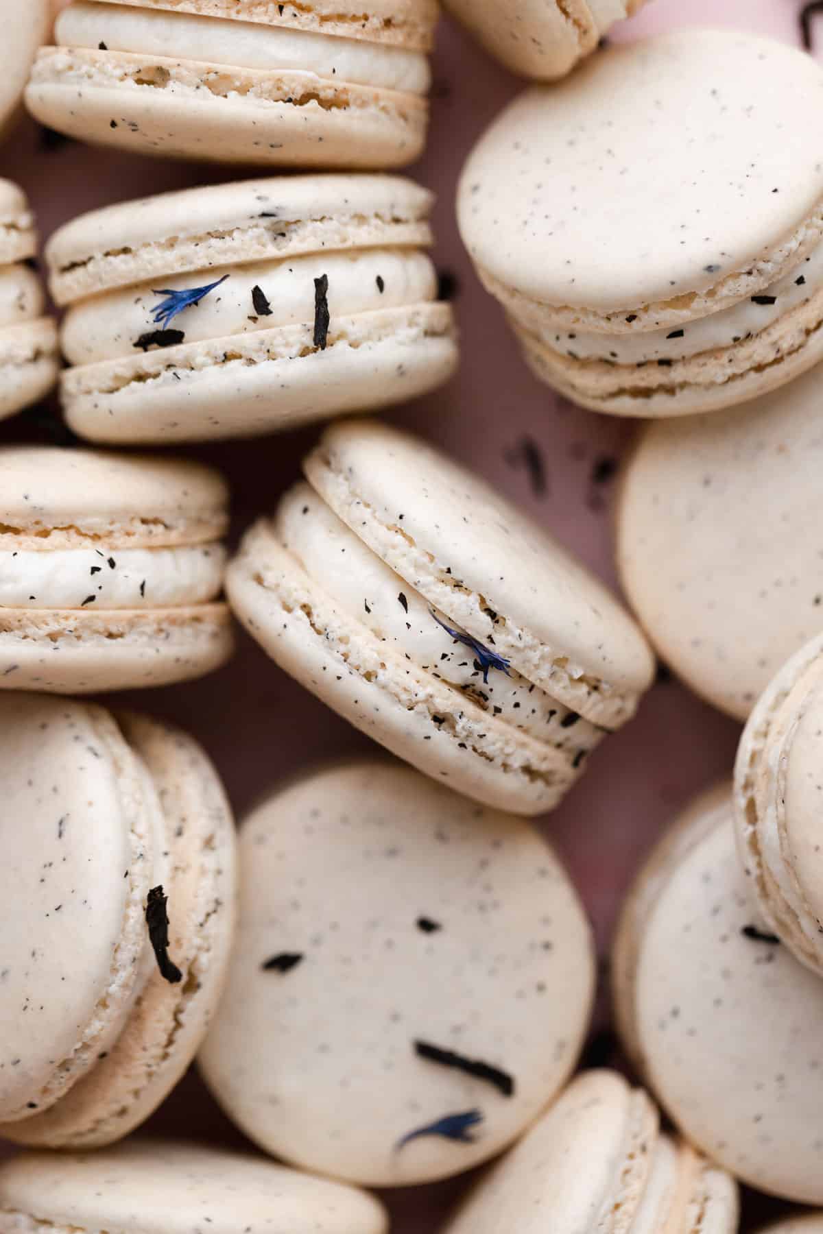 earl grey macarons sprinkled with earl grey tea on a countertop.
