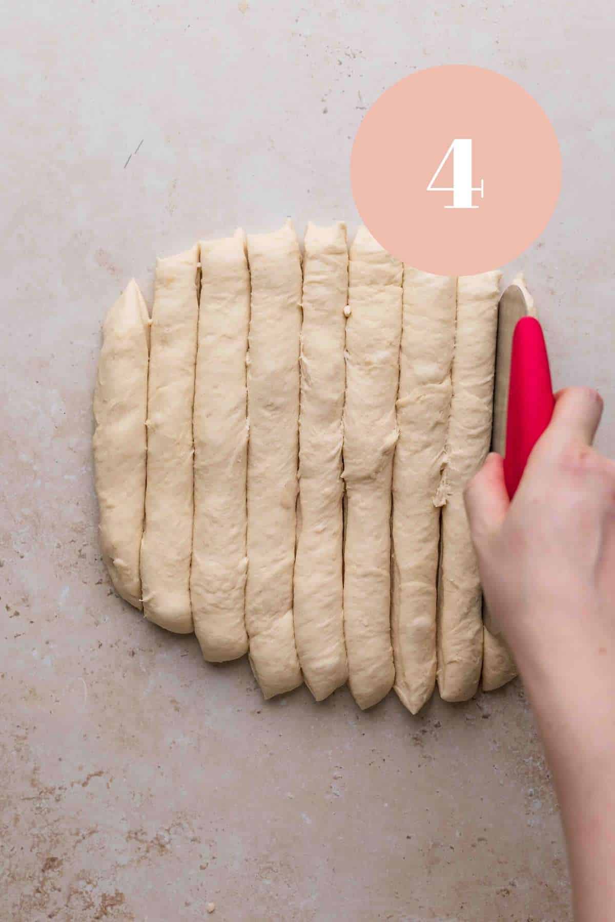 cutting the parmesan bread dough in strips.