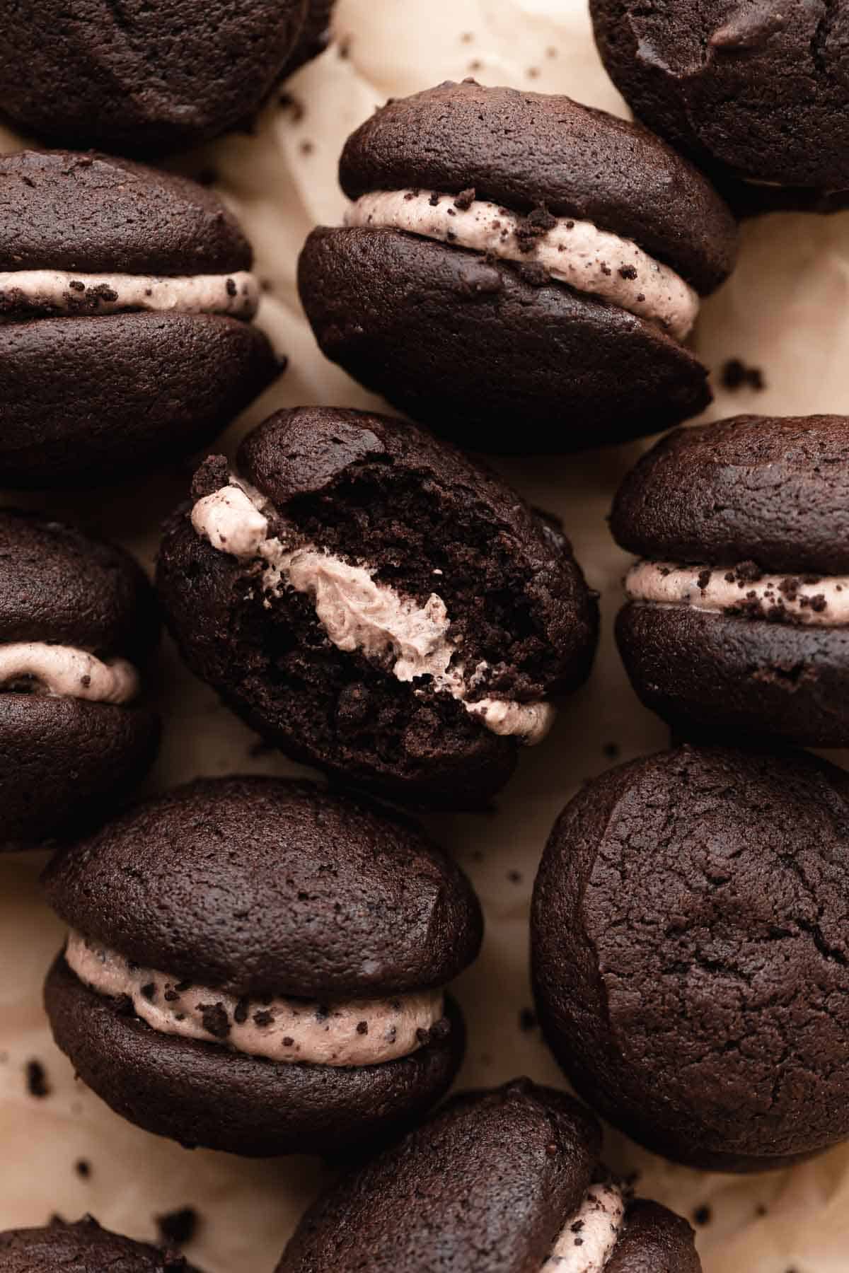an oreo whoopie pie with a bite taken out of it.