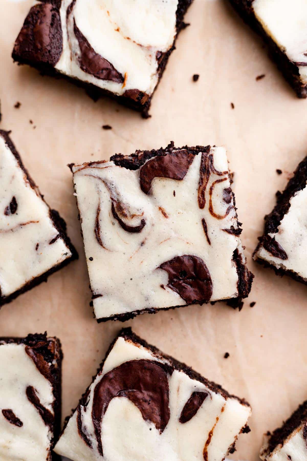 marble brownies cut into squares on a piece of parchment paper.