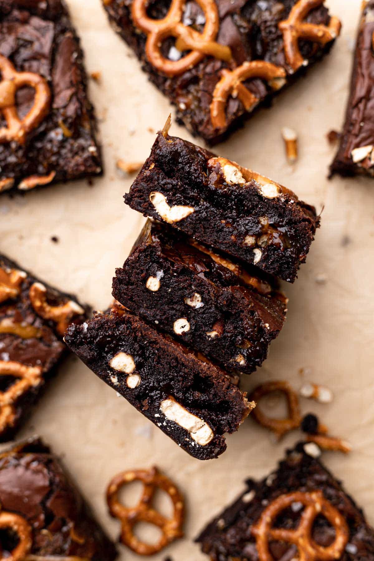 brownies with pretzels on a parchment lined tray.