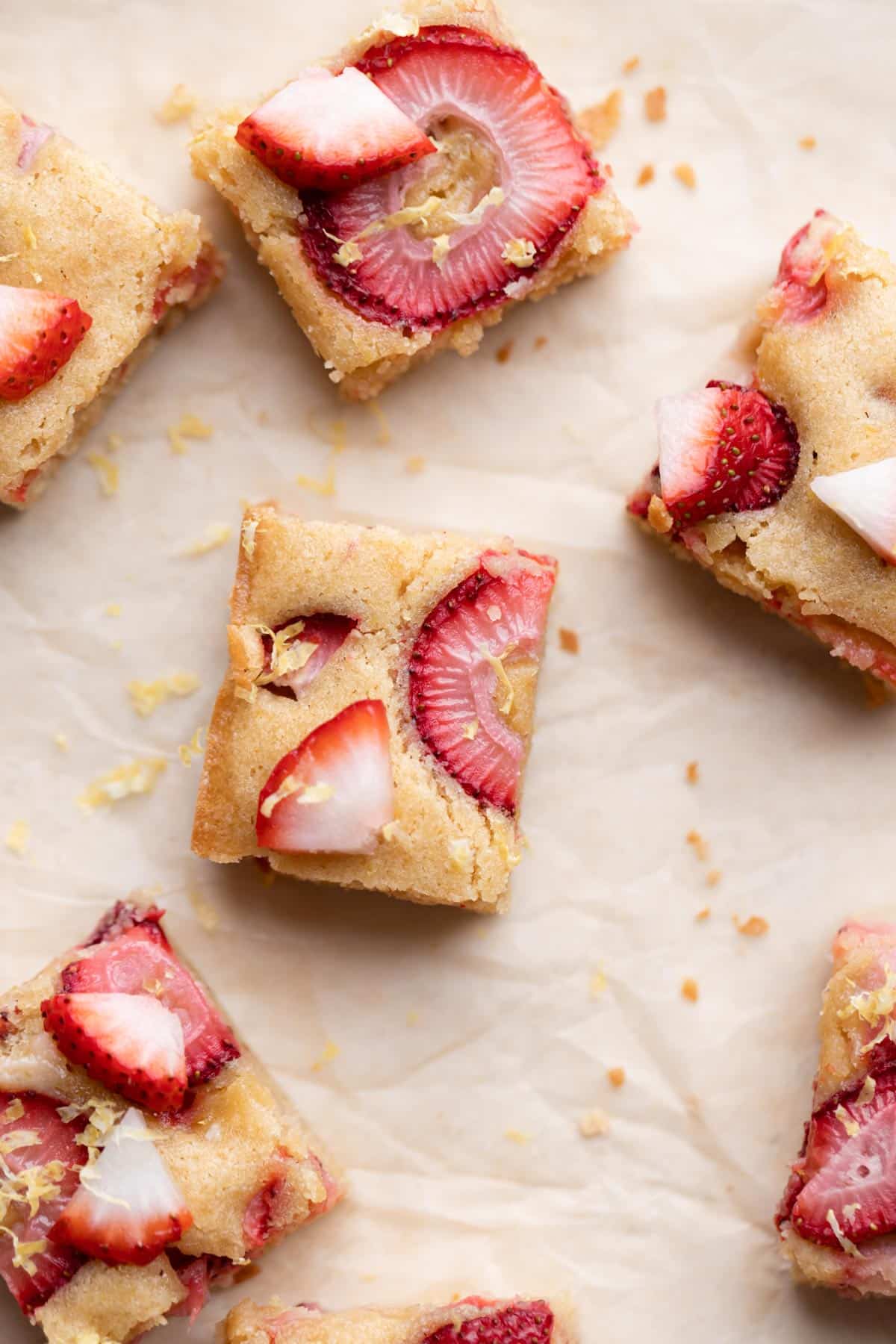 strawberry blondies sitting on a piece of parchment paper.