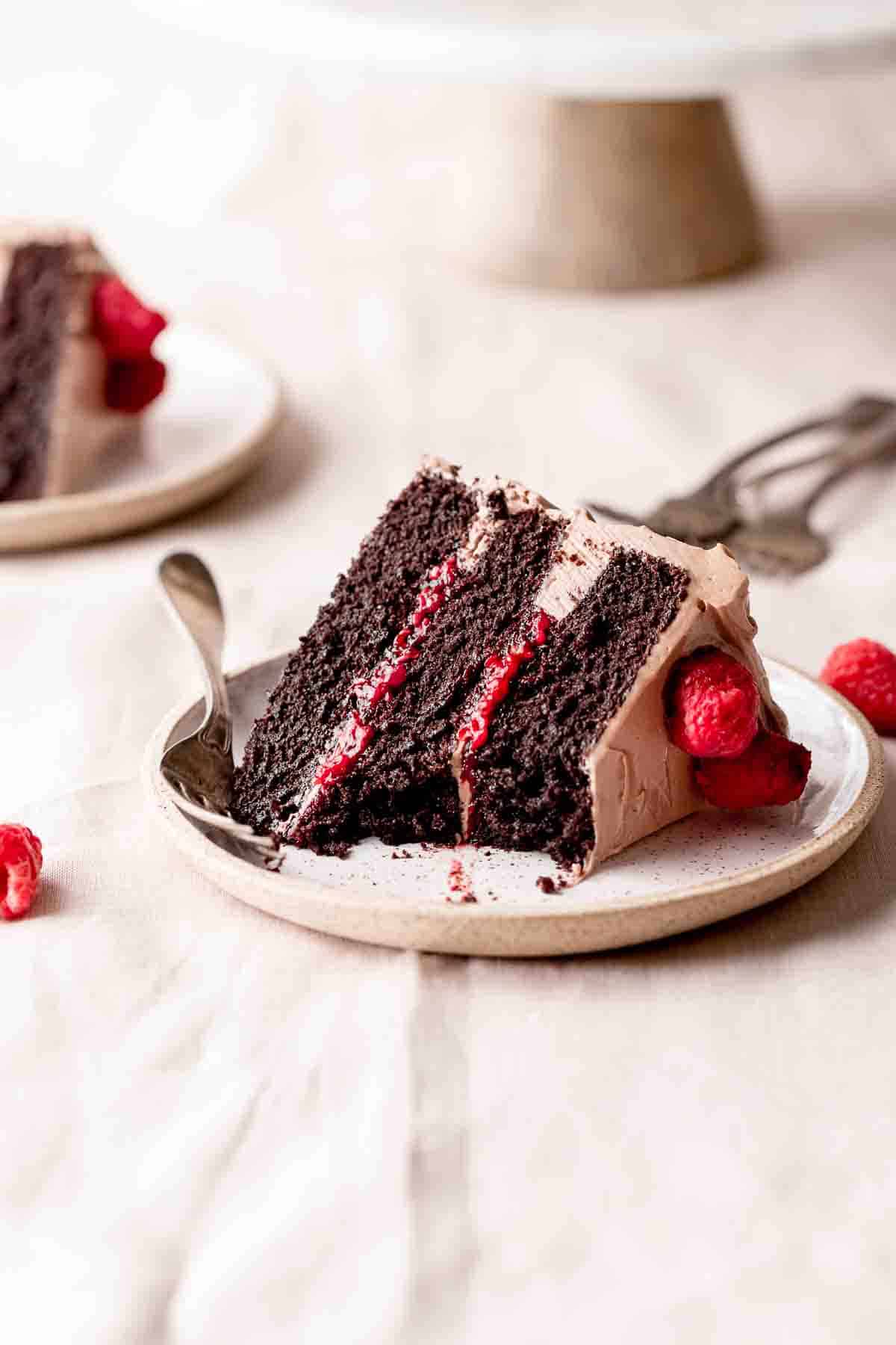 a slice of dark chocolate raspberry cake on a plate.