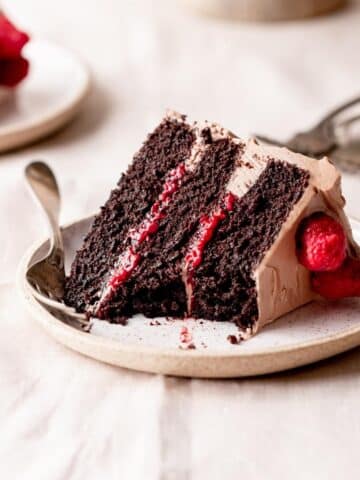 chocolate cake with raspberry filling on a cake stand.