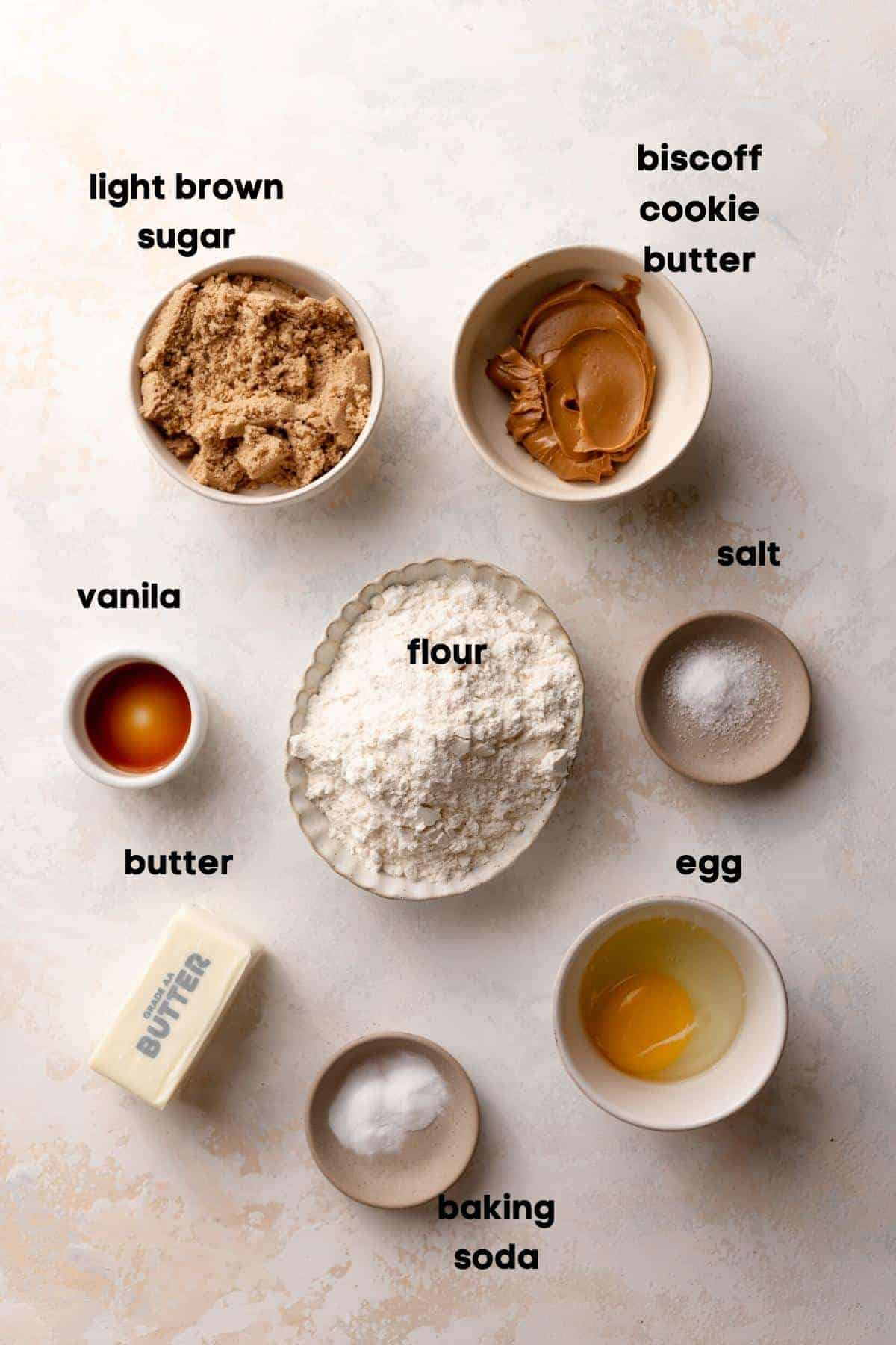 ingredients needed for biscoff butter cookies in bowls with labels.
