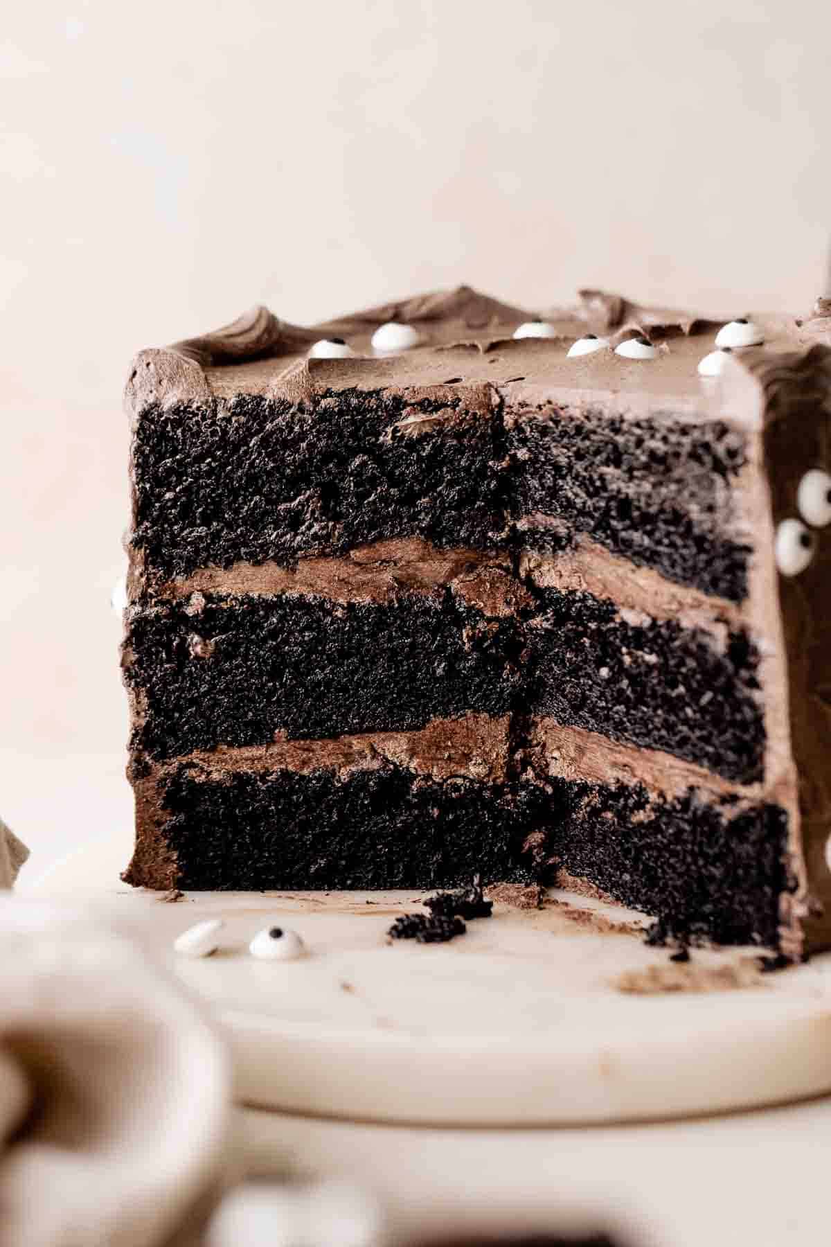 black velvet cake with black cocoa buttercream on a marble round.