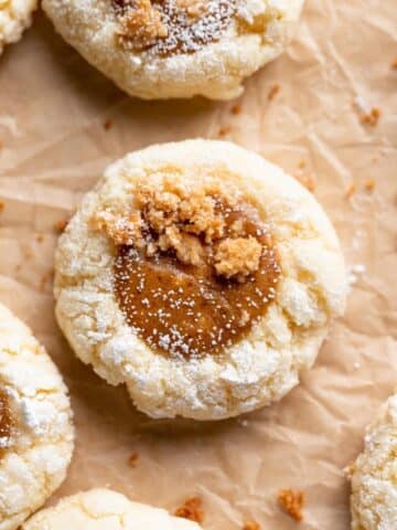 pumpkin cheesecake cookies with a cheesecake center on parchment paper.