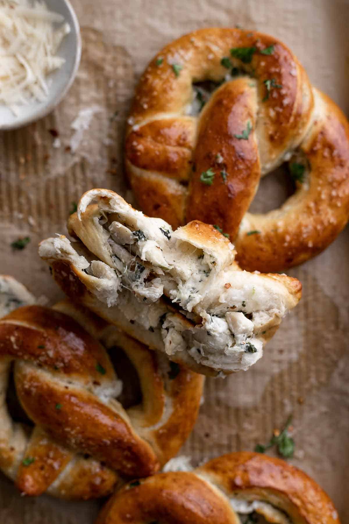 a pretzel ripped in half to show they are stuffed with spinach artichoke filling.