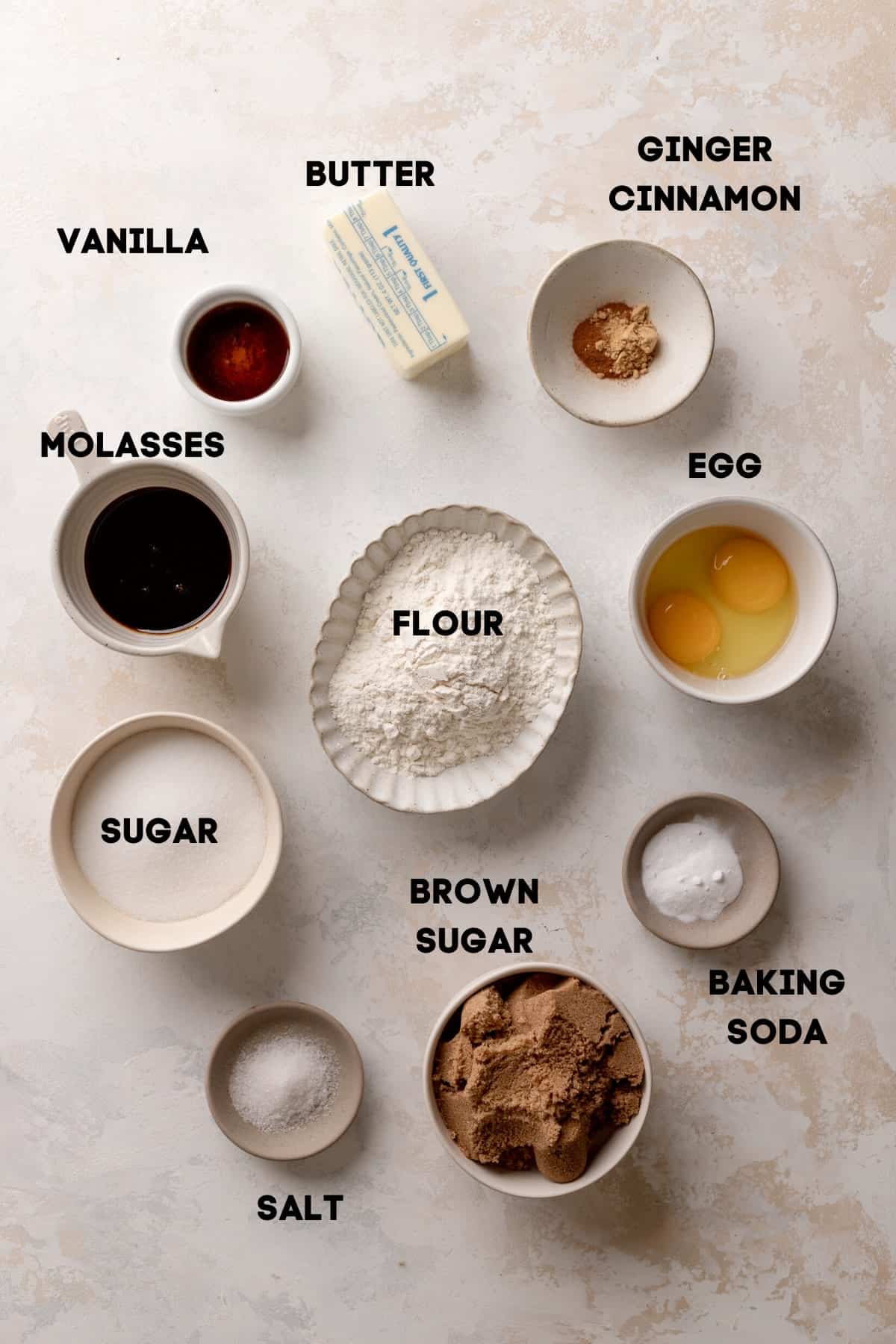 the ingredients needed to make molasses crinkle cookies in bowls.
