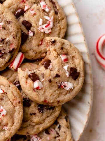 chocolate chip peppermint cookies topped with crushed candy canes in a white dish.