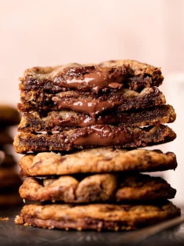 chocolate filled cookies in a stack with nutella oozing out of the centers.