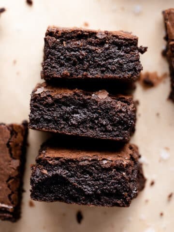three espresso brownies stacked to show their fudgy texture.