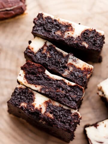 four marble brownies stacked to show the cheesecake and brownie swirl.
