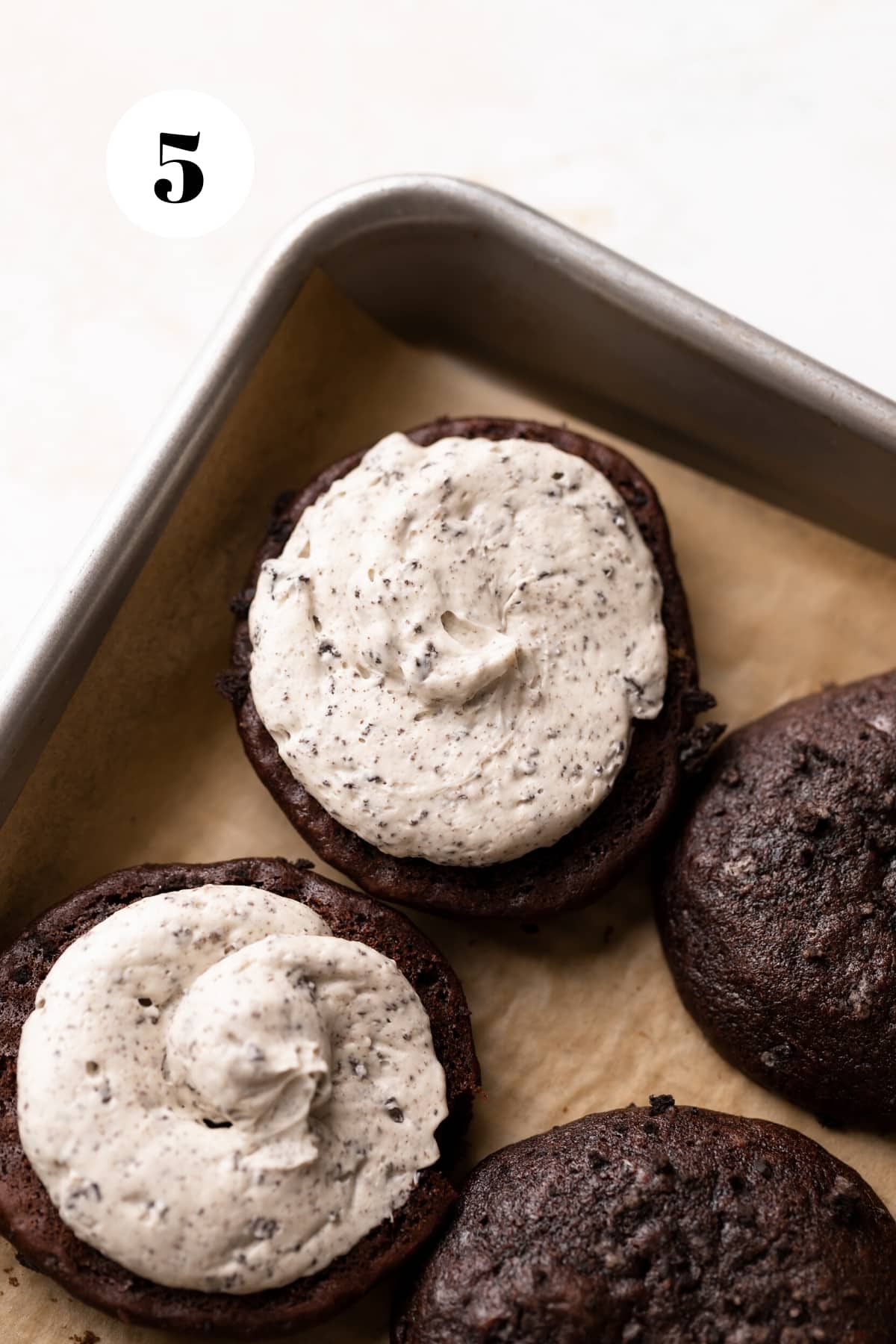chocolate whoopie pie cookie with oreo buttercream piped onto the center.