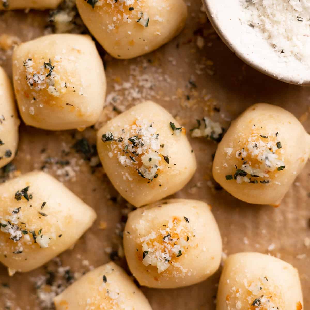 parmesan bread bites covered in parmesan cheese and fresh herbs.
