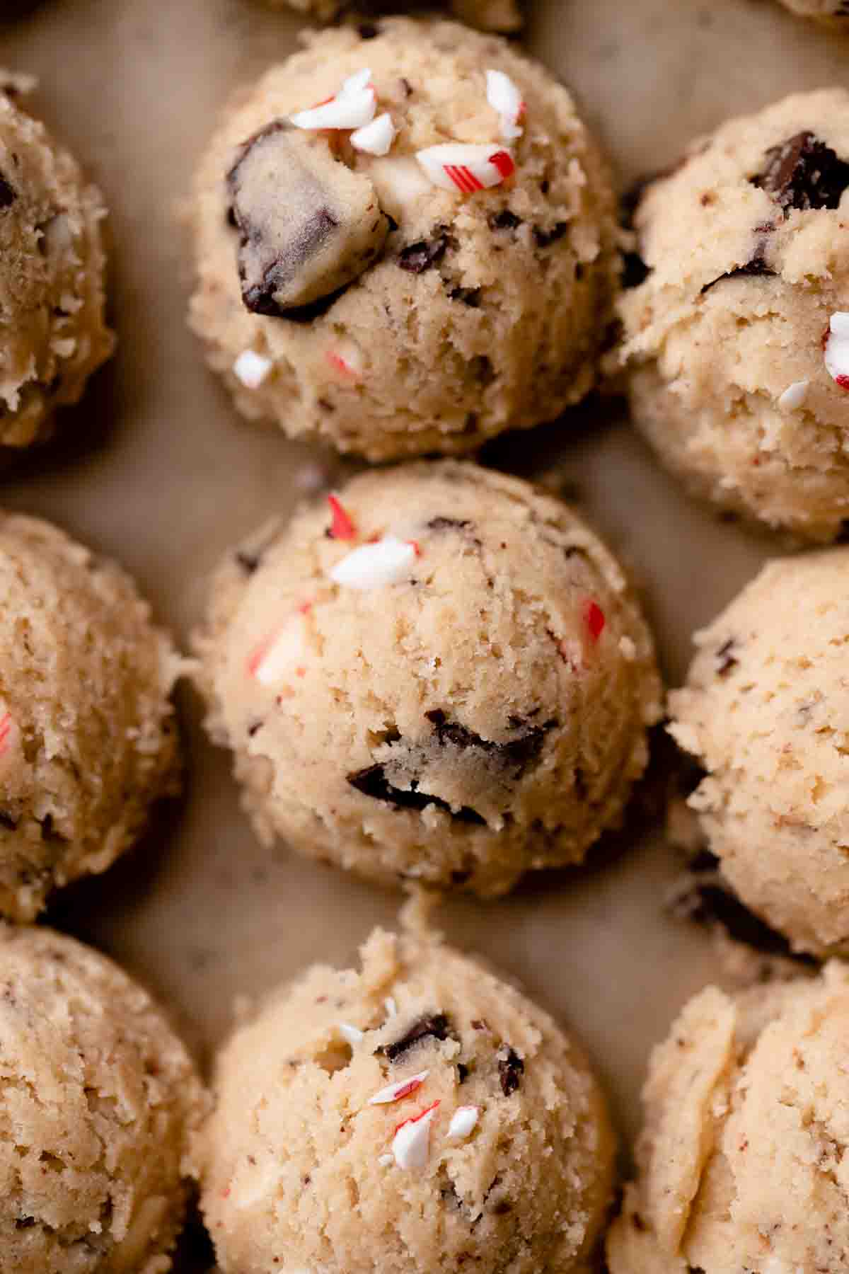 chocolate chip cookie dough balls with peppermint candy cane pieces on top.