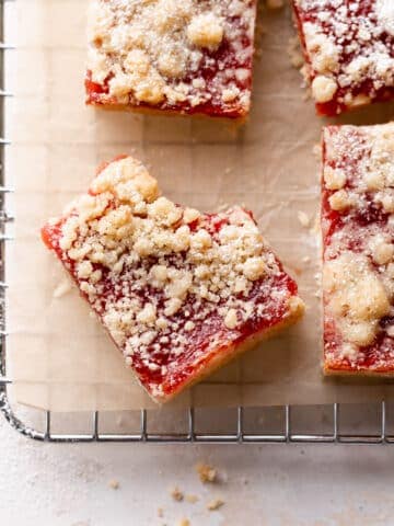 plum bars on a wire cooling rack dusted with powdered sugar.