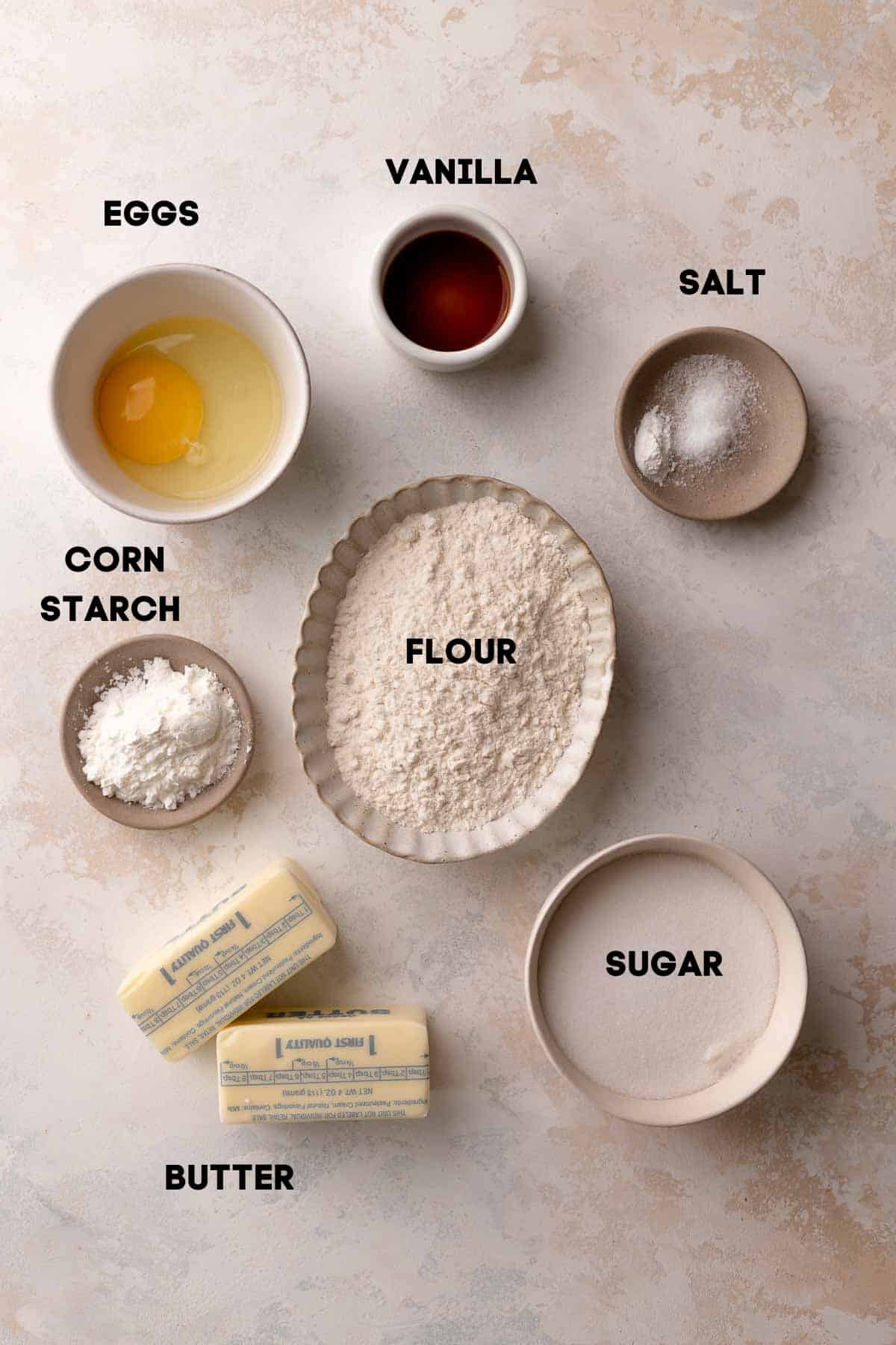 ingredients needed to make the shortbread cookie dough in bowls with labels.