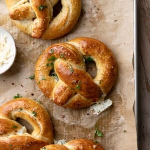 stuffed pretzels brushed with butter on a baking tray.