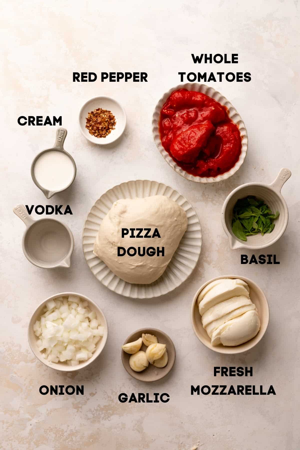 ingredients needed to make pizza with vodka sauce in bowls with labels.