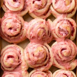 strawberry cinnamon rolls covered in strawberry cream cheese icing.