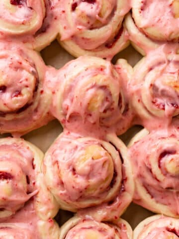 strawberry cinnamon rolls covered in strawberry cream cheese icing.