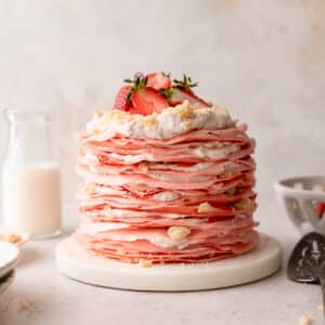 crepe cake layered with whipped cream, crumble, and fresh strawberries.