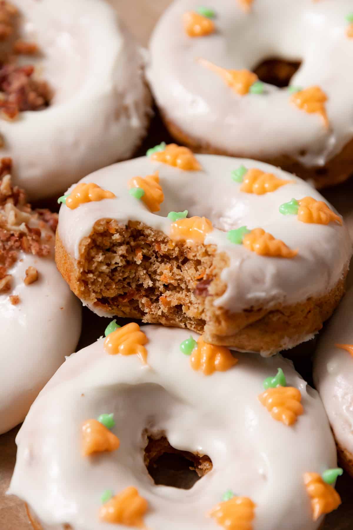 baked carrot cake donut with a bite taken out of it.