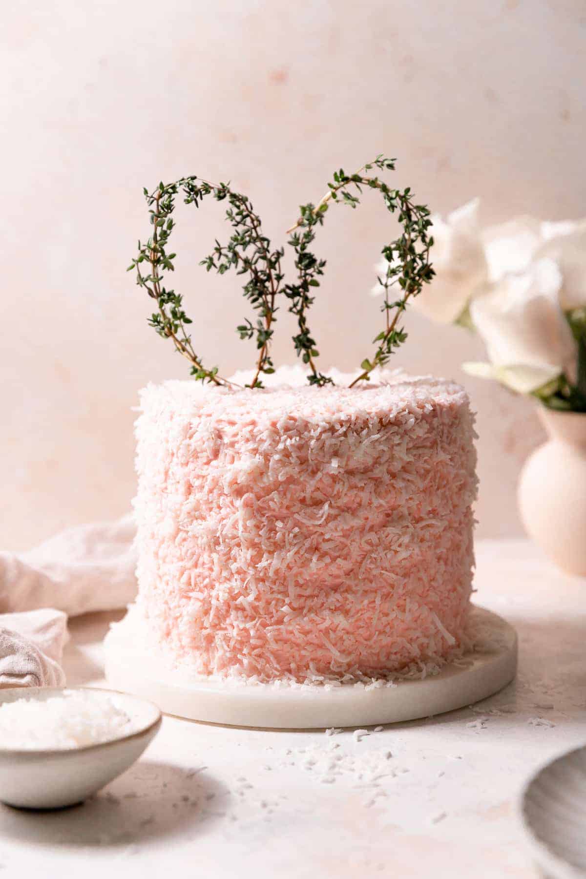 pink easter coconut cake covered in shredded coconut.