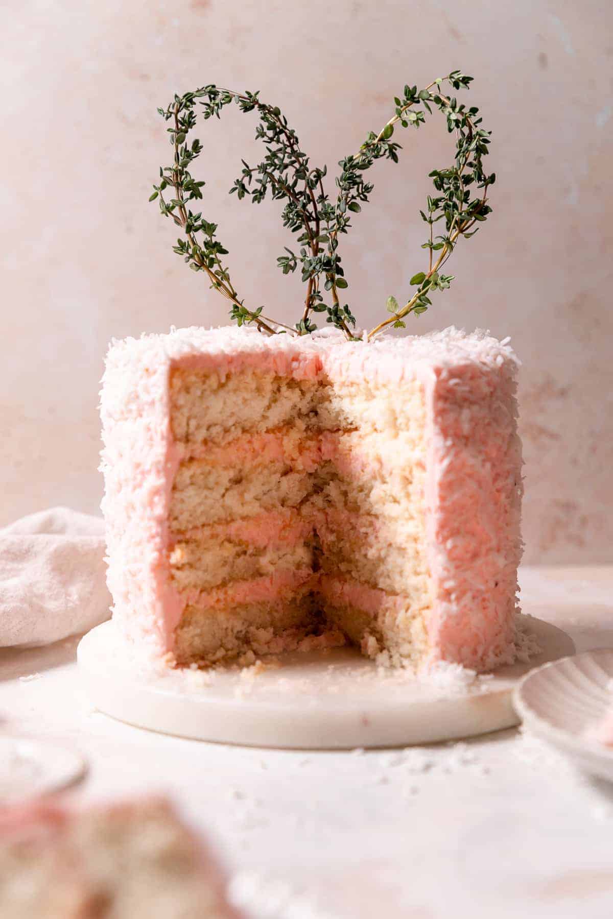 easter coconut cake with slices cut out to show the texture of the cake.