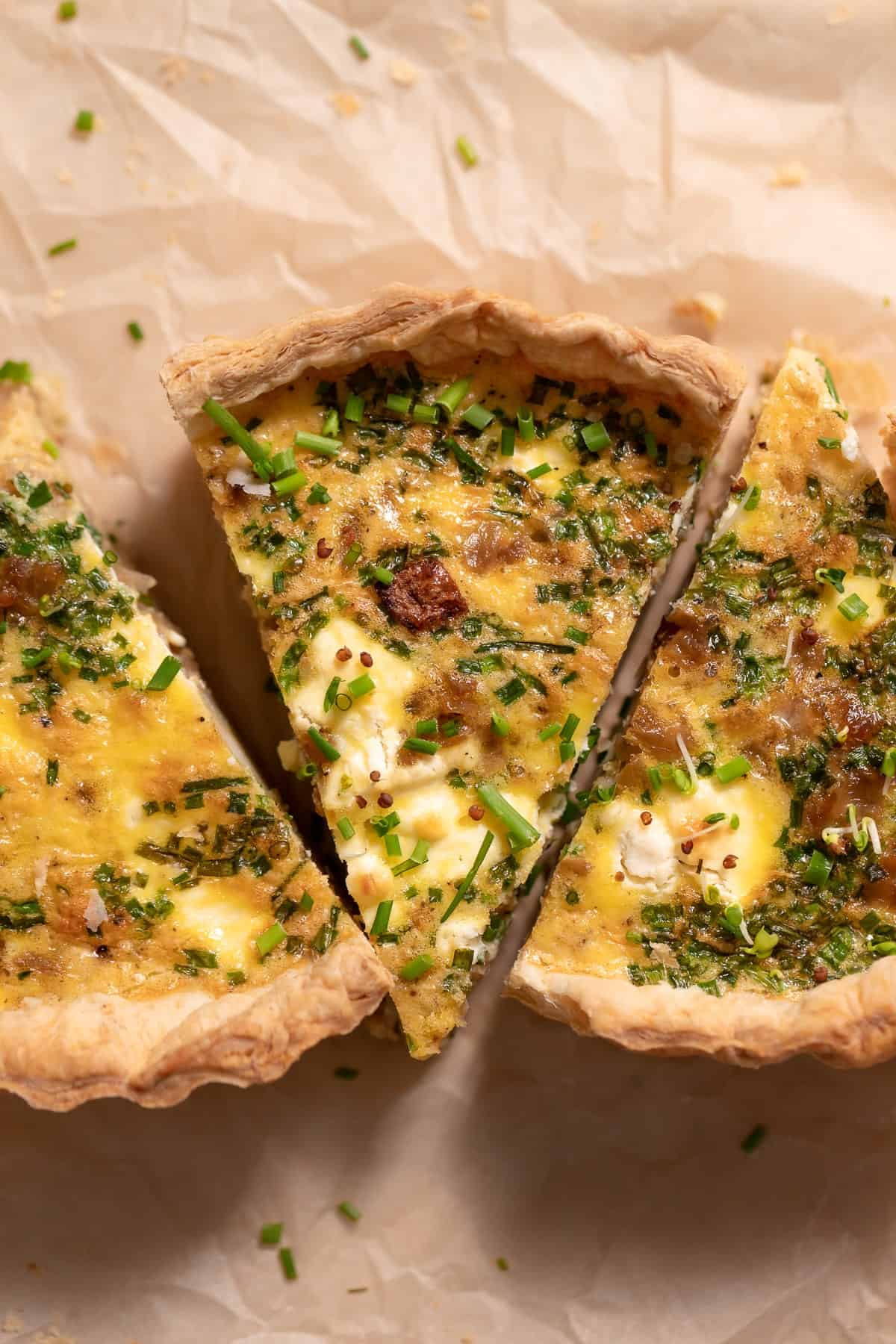 three slices of quiche on parchment paper.