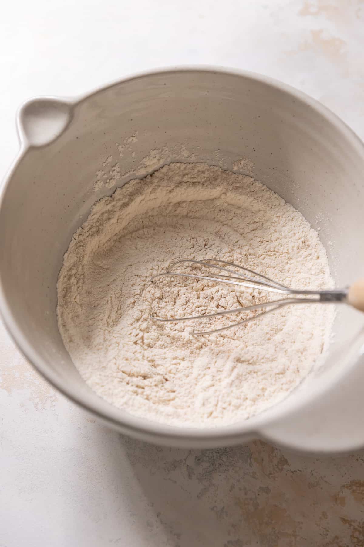whisking the dry ingredients together in a mixing bowl.