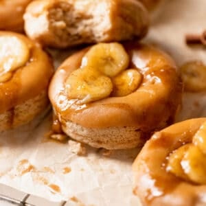 baked banana donuts with brown sugar glaze and bananas on top.
