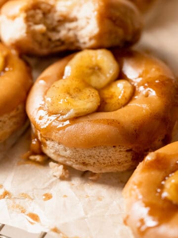 baked banana donuts with brown sugar glaze and bananas on top.
