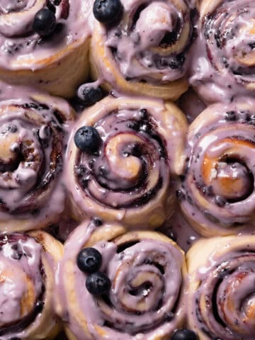 blueberry cinnamon rolls with blueberry glaze on top.