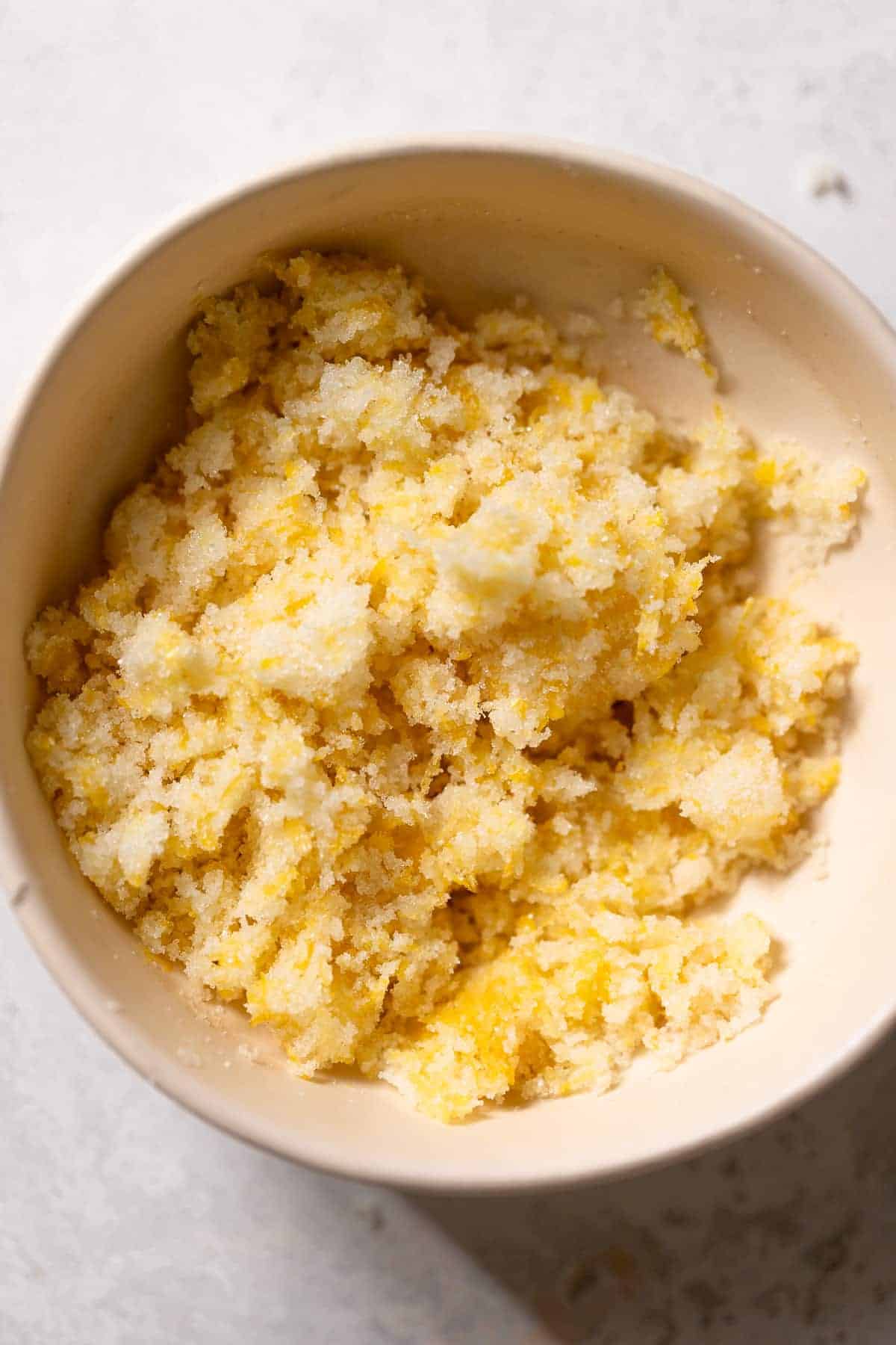 fresh lemon zest and sugar rubbed together in a mixing bowl.