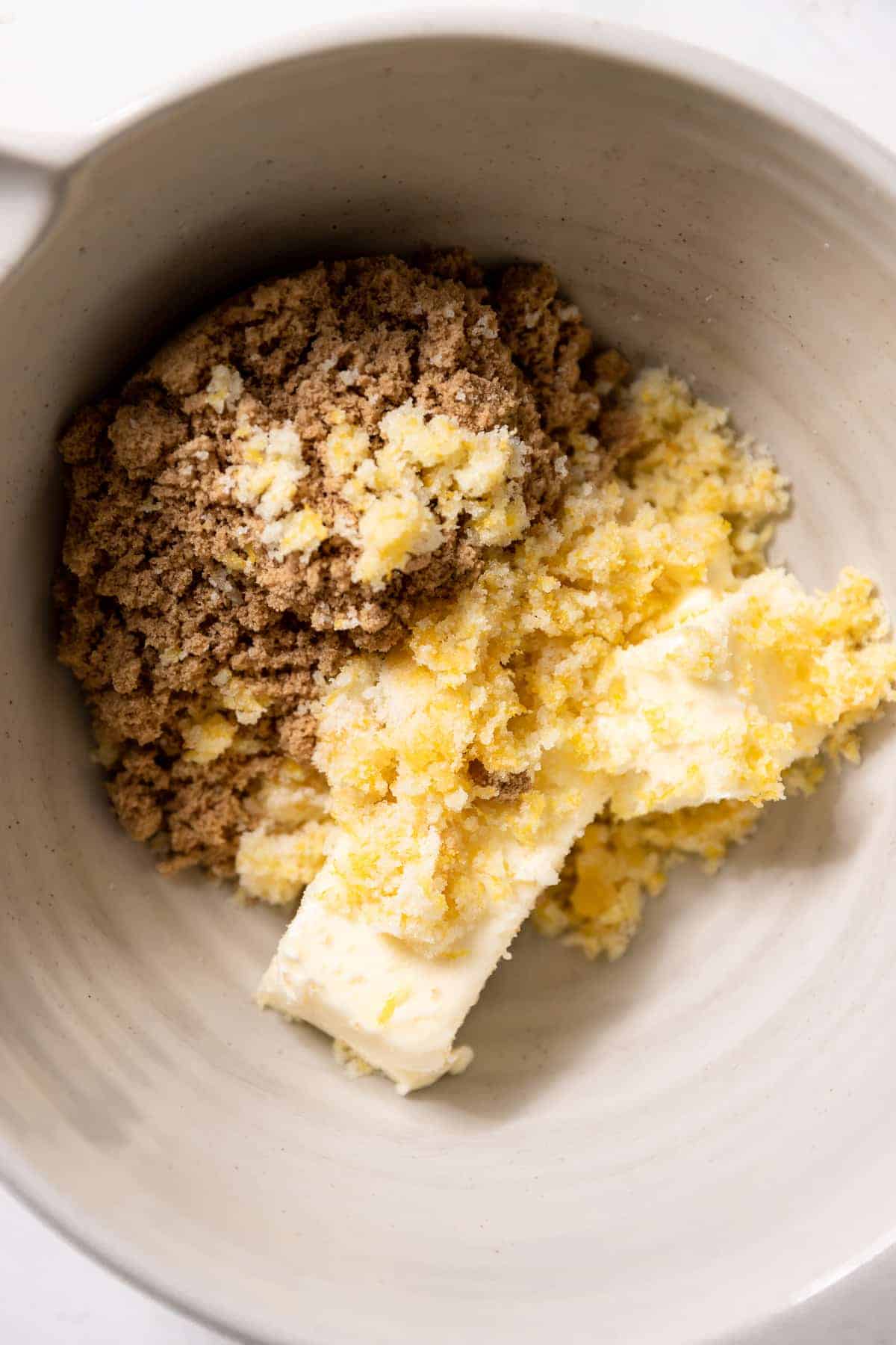 a mixing bowl with sugar, brown sugar, and butter.