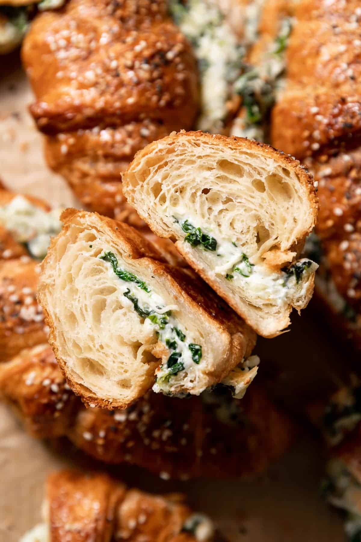 spinach croissant cut in half to show the cheese and spinach filling.