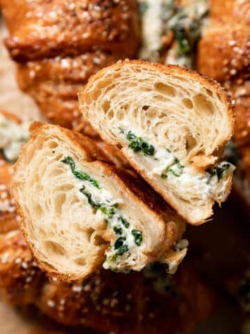a spinach croissant cut in half to show the cheese filling.