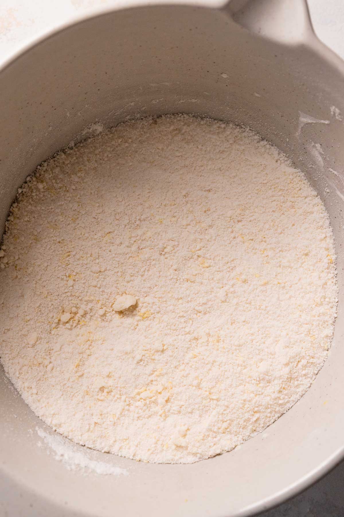 dry ingredients and butter mixed together in a mixing bowl.