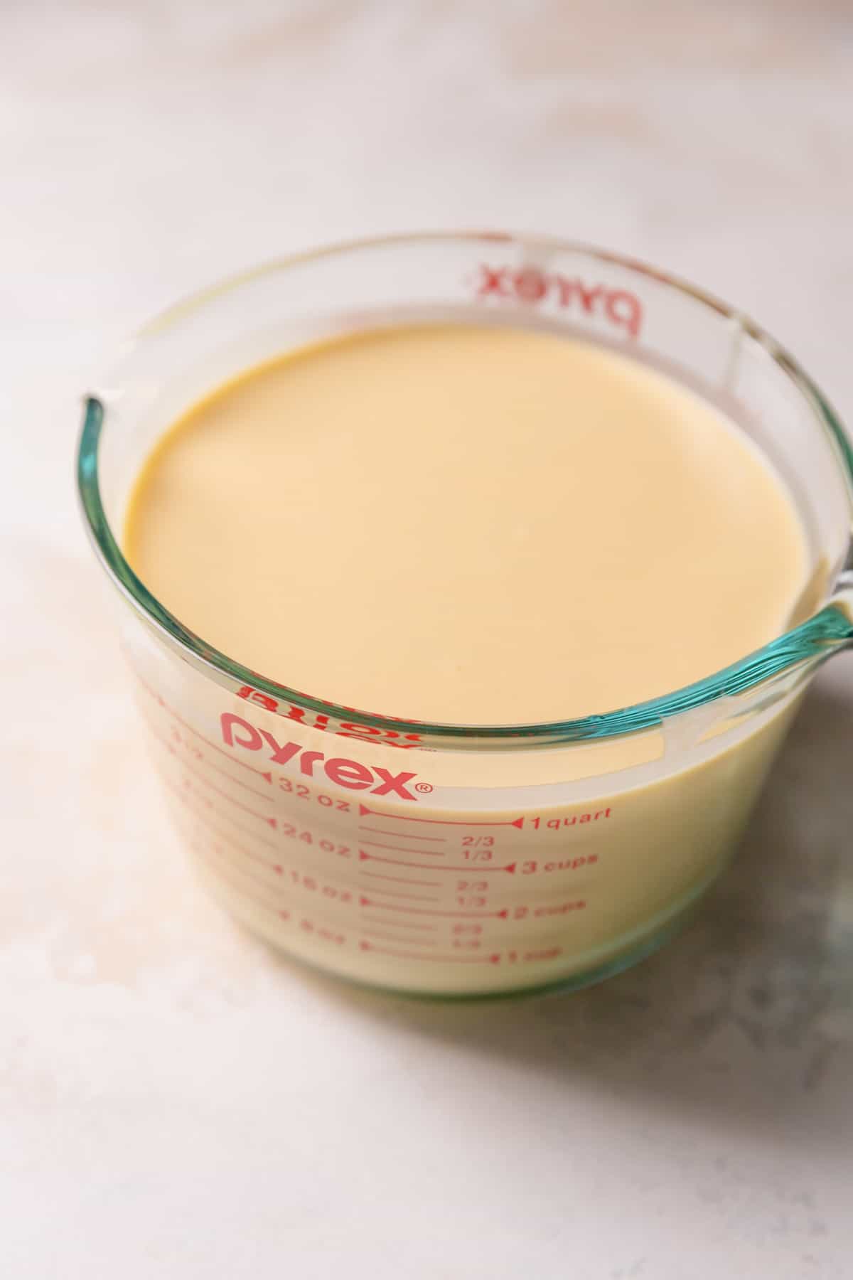 crepe batter in a glass measuring cup.