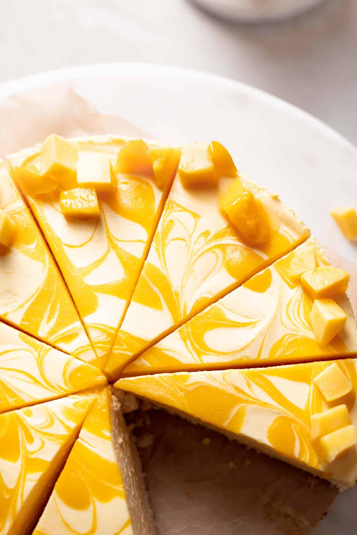 mango mousse cake with swirled mango puree on top.