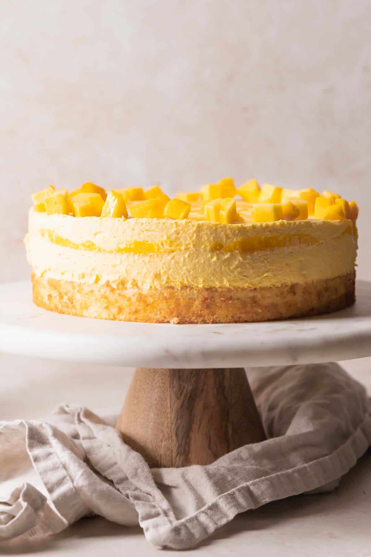 mango mousse cake on a cake stand.