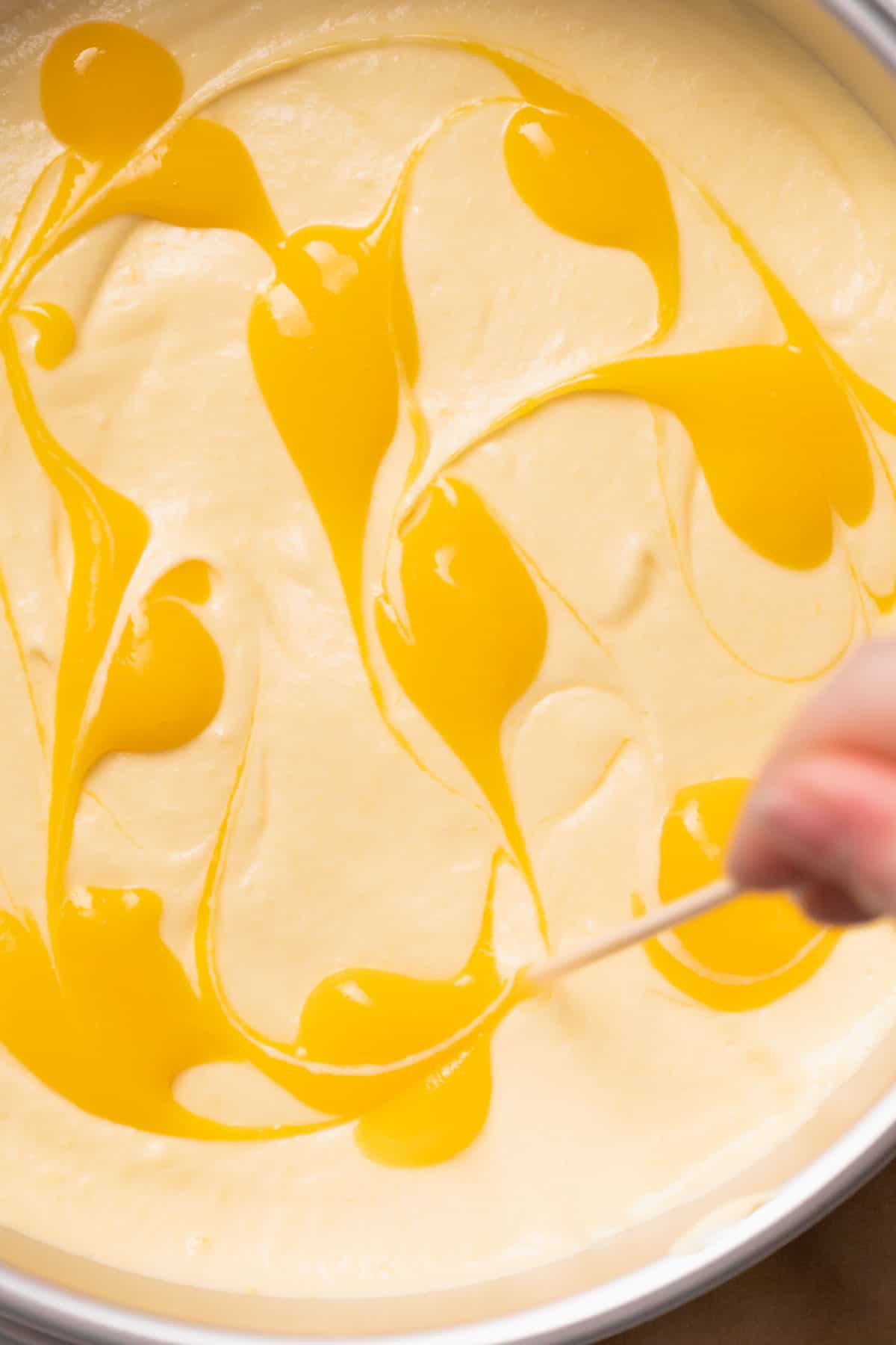 swirling mango puree onto the top of the mousse cake.