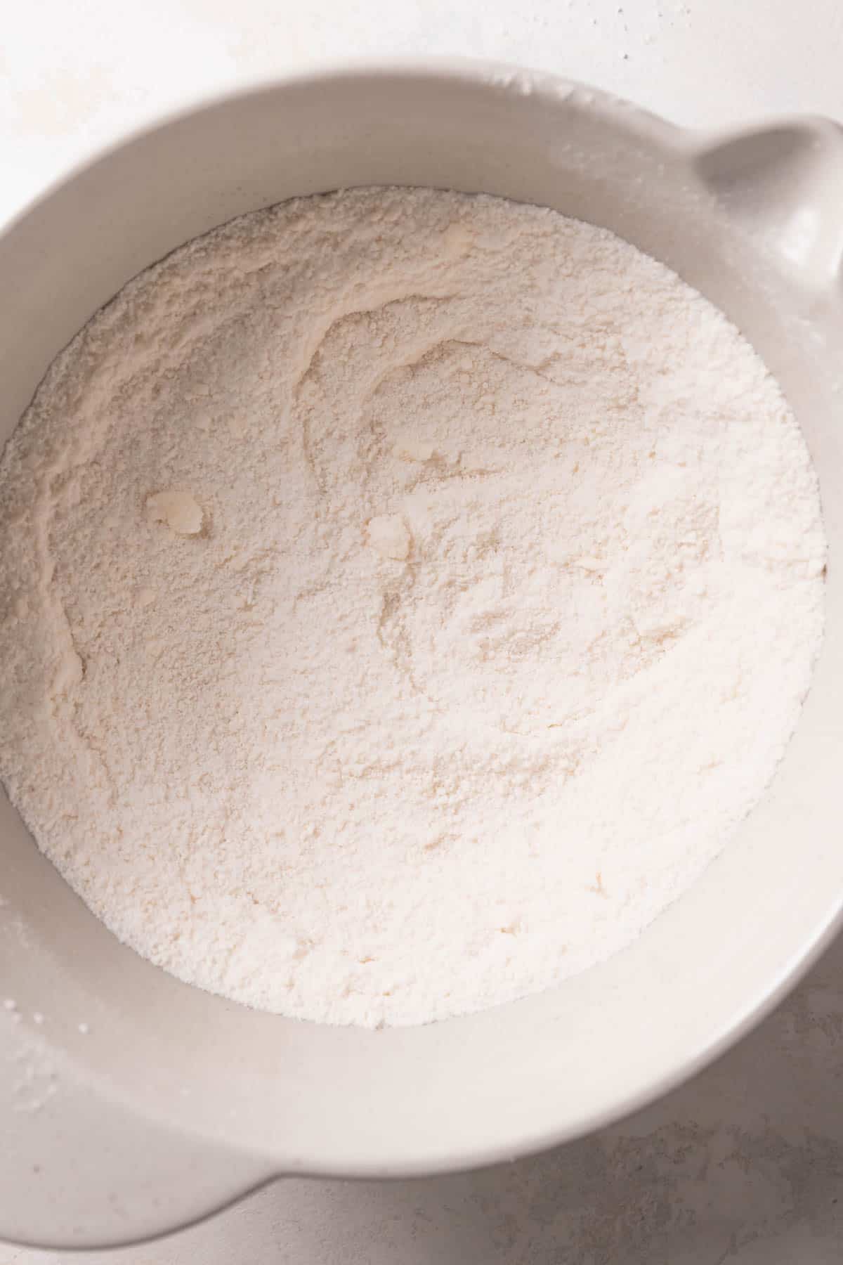 butter and dry ingredients mixed together in a bowl.