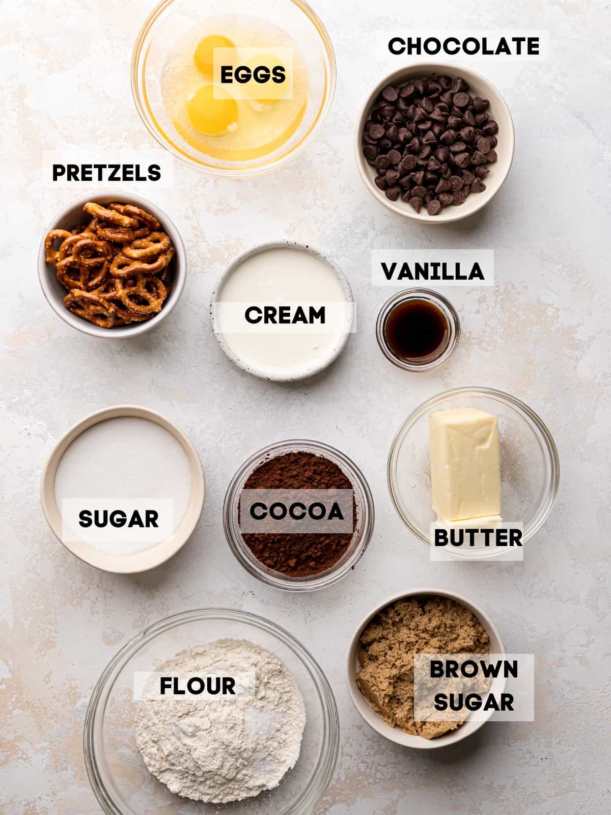 ingredients needed to make pretzel brownies in bowls with labels.