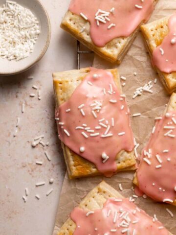 homemade pop tarts with pink glaze and white sprinkles.